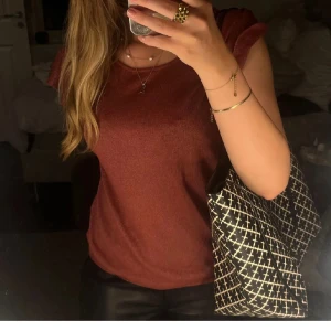 Rostfärgad topp med volangdetalj - Snygg rostfärgad topp med volangdetalj vid ärmarna. Toppen är ärmlös och har en rund halsringning. Så så fin och går inte att köpa längre🥰💌🍸storlek L men passar mer M/S storleksmässigt. Fint sick!!