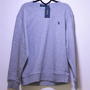 Polo Ralph Lauren Sweatshirt - Helt ny Ralph Lauren sweatshirt med det klassiska logotypbroderiet på bröstet. Tröjan har långa ärmar och en rund halsringning. Perfekt för en avslappnad och snygg look. Fler storlekar finns i min profil.😊