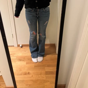 Blå bootcut jeans med hål - Snygga blå bootcut jeans med hål! De är använda men i bra skick men har några slitningar. 