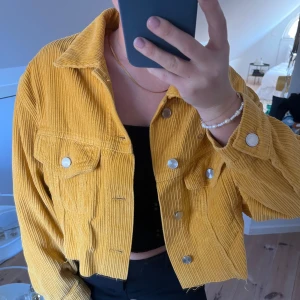Gul manchesterjacka från Karve - Snygg gul manchesterjacka från Karve med knappar framtill och två bröstfickor. Jackan är croppad och lite oversized! Storlek S