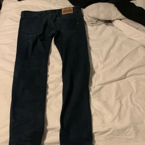 Mörkblå jeans från Replay - Snygga mörkblå jeans från Replay, modell Anbass. Dessa jeans har en slim fit passform och är perfekta för en stilren look. Klassisk design med fem fickor och dragkedja.