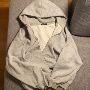 Brandy Melville zip up  - Grå Brandy Melville zip up hoodie I one-size storlek, köpte den på vinted men den passade tyvärr inte mig som jag hade velat. Har blivit använd några gånger av dess tidigare ägare men ser inga större synliga tecken på skador eller slitage. Hör gärna av dig för fler bilder eller mått!💞 