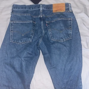 Levi's 501 jeans - Klassiska Levi's 501 jeans i blå denim. De har en rak passform med knappgylf och fem fickor. Perfekta för en avslappnad stil. Pris diskuteras vid en snabb affär