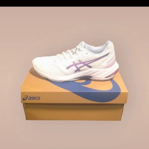 Asics netburner ballistic ff3  - Snygga och bekväma vita träningsskor från Asics med lila detaljer. Perfekta för löpning eller gymträning. Skorna har snörning för optimal passform och en dämpad sula för extra komfort. Nya oanvända, nypris 1499kr