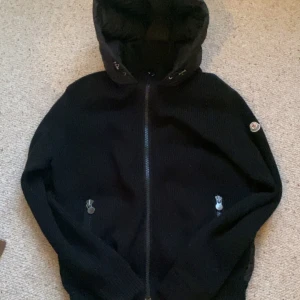 Moncler cardigan - Snygg svart still ren moncler tricot cardigan med huva och dragkedja.😎 Jackan har ett quiltat mönster på baksidan och Moncler-logga på ärmen. Perfekt för kyligare dagar✌️. Själv klart äkta mvh Frank