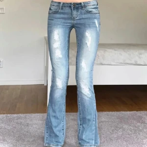 Blå jeans  - Snygga jeans med ”slitningar”,  midjemått 73, Innerbenslängden 78