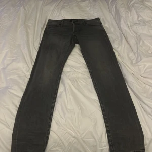 Svarta slim jeans från Jack & Jones - Säljer ett par svarta slim fit jeans från Jack & Jones, modell Glenn. De är i bra skick och har en klassisk femficksdesign med dragkedja. Perfekta för både vardag och fest! 🖤
