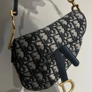 Dior saddle  - Christian Dior saddle bag i mycket fint skick. 19cm 15 cm hög  Dustbag och kartong finns kvar. 