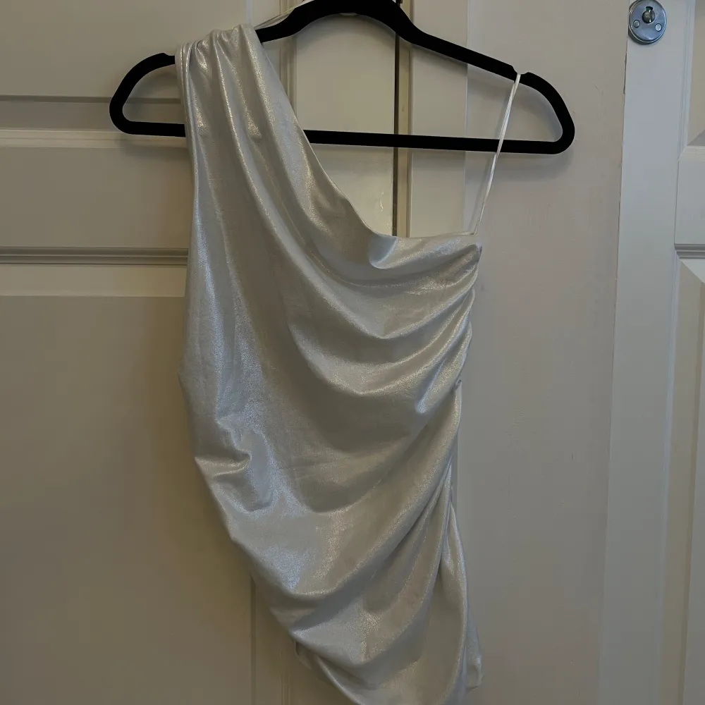 Vitglittrig, stretchig topp som formar kroppen. Toppen är felfri och säljs då den tyvärr inte kommer till användning hos mig. Toppen är köpt på H&M i storlek S men passar både på mindre och större storlekar då toppen är såpass stretchig. 💗💗. Yläosat.