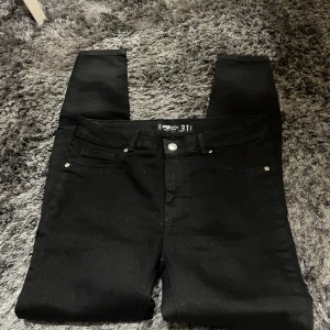 Svarta skinny jeans från FB Sister - Säljer ett par svarta skinny jeans från FB Sister i storlek 31. De har en push-up effekt och är perfekta för en snygg och tight look. Jeansen är i bra skick och passar till både vardag och fest. Perfekta för höst och vinter!