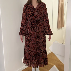 Röd leopardmönstrad långklänning - Klänning från Vila i strl 34 med volang. Använd ca 2 ggr, nyskick. Skriv för mer info