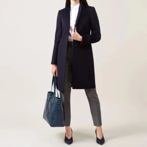 Hobbs Ullkappa, mörkblå, storlek 36 - En elegant kappa i mörkblå färg med en enkel och klassisk design. Kappan är i gott skick och har inte använts mycket. Brand: HOBBS Storlek: 36  Model: Tilda wool coat Färg: Navy Dry clean only 100% Wool/ Ull Nypris i butiken: 4250Kr 