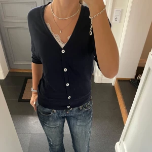 Mörkblå stickad kofta  - Trekvartsärmad stickad kofta från H&M i storlek 38, passar S och M. Fint skick. Använd gärna köp nu!