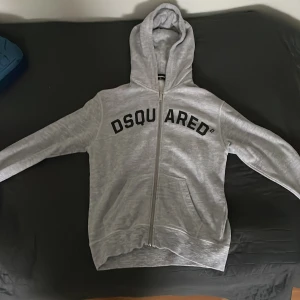 DSQUARED2 Tröja med luva - Säljer denna feta DSQUARED2 Tröjan eftersom den är lite för stor för mig. Den är självklart äkta. Strl 14 men är lite stor i storleken. Köpt för 1499:-. Använd 2 ggr inom. Ägt den i 1 månad. 
