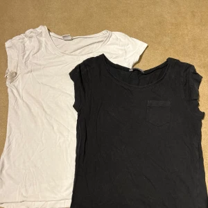 Två t-shirts från Lindex Kids - Säljer två t-shirts från Lindex Kids i storlek 170. En vit och en svart, båda med korta ärmar. Den svarta och vita har en liten bröstficka. Perfekta för vardagsbruk och enkla att matcha med olika outfits.