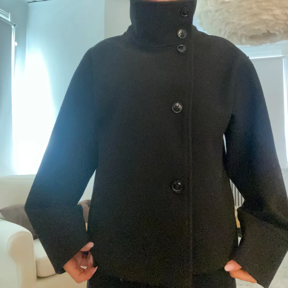 ”Short felt jacket” från Gina Tricot. Svart kappa med hög krage och knappar. Jättebra skick och inga defekter, säljer pågrund av många liknande. . Jackor.