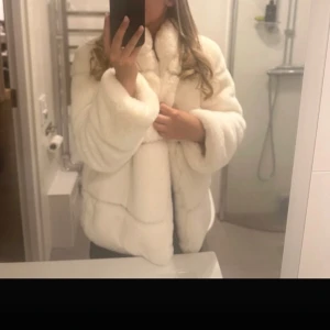 Vit pälsjacka fuskpäls  - Så fin fuskpäls jacka. Går att knäppa med en liten hake. Står strl L men skulle säga att small-large kan ha den. 