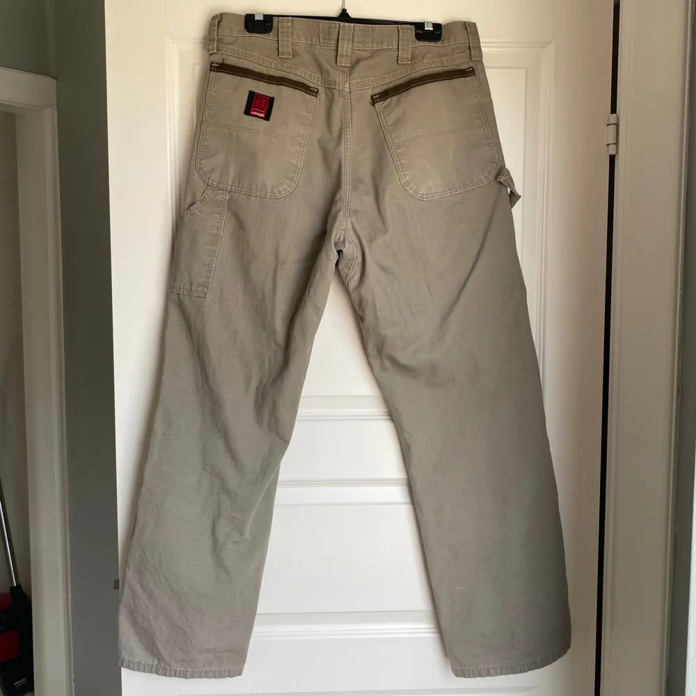 Riggs workwear jeans by Wrangler. Normal i storleken men de är i en mer ”oversize”/baggy stil. Köpta second hand men relativt gott skick (har en defekt på framsidan, se bild 4). Storlek 34x32 (L). Jeans & Byxor.