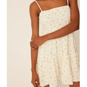 Vit blommig klänning från Lisa & Lena - Söt vit klänning med små gula blommor från NA-KD. Den har smala justerbara axelband. Storlek 38 och aldrig använd, därmed nyskick. 