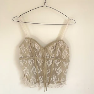 Söt Spets Top - Super söt korsett topp i oliv pastel. Vina vita spets detaljer. Super bra skick, passar bra till festliga kvällar 🤍 STRL S
