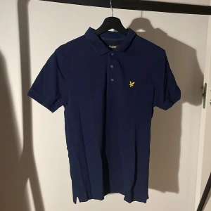 Mörkblå pikétröja från Lyle & Scott, storlek M - Säljer en snygg mörkblå pikétröja från Lyle & Scott i storlek M. Säljer massor av olika sorters kläder/färger från lyleandscott i min profil. Nypris:750kr