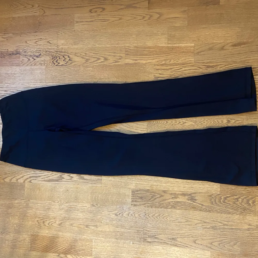 Säljer ett par snygga svarta leggings i bootcut-stil. De är perfekta för både träning och vardagsbruk. Materialet är mjukt och stretchigt, vilket gör dem superbekväma att ha på sig. Nypris 500kr. Jeans & Byxor.