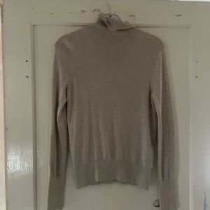 Beige polotröja från ONLY - Säljer en stilren beige polotröja från ONLY i storlek S. Tröjan är perfekt för kyligare dagar med sin mjuka och bekväma passform. Den har långa ärmar och en klassisk polokrage som håller dig varm och snygg. Passar både till vardags och lite finare tillfällen!