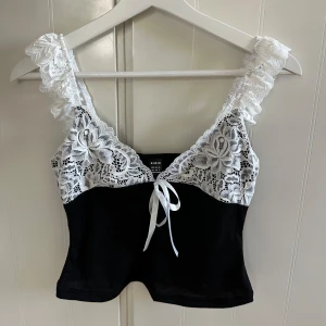 Fin spets topp - Säljer en fin spets topp, svart och vit, super fint skick, med söta detaljer, pris kan diskuteras!💕