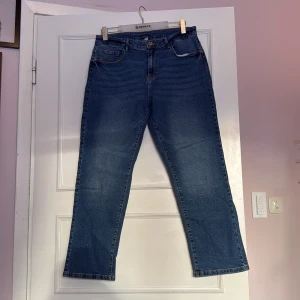 Blå jeans från Vila - Snygga blå jeans från Vila med klassisk femficksdesign, De har en rak passform och är perfekta för en avslappnad stil. Jeansen har en hög midja och är tillverkade i ett slitstarkt denimtyg.