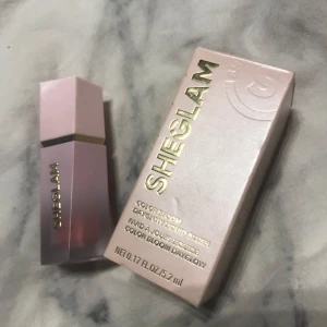 Sheglam Color Bloom Liquid Blush i nyansen Love Cake - Säljer en Sheglam Color Bloom Liquid Blush i nyansen Love Cake. Denna flytande rouge kommer i en elegant rosa förpackning med guldtext. Perfekt för att ge kinderna en fräsch och rosig ton.