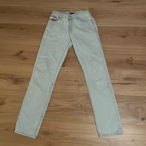 Ljusblå jeans från Tommy Hilfiger - Snygga ljusblå jeans från Tommy Hilfiger med klassisk femficksdesign. De har en rak passform och är perfekta för en avslappnad stil. Märkeslogga synlig på baksidan. Perfekt för dig som gillar stilrena och tidlösa plagg.