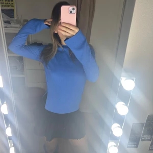 Blå långärmad tröja - Säljer en snygg blå långärmad tröja. Perfekt för en stilren look. Passar bra till både kjol och byxor. Har även en liten slits på sidan av tröjan. Använd ett fåtal gånger så den är i mycket bra skick.