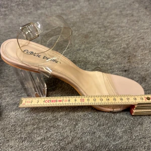 Transparenta klackskor från Public Desire - Snygga klackskor med transparenta remmar och klack från Public Desire. Skorna har en beige sula och en stilren design som passar perfekt för en trendig look.