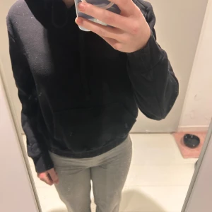 Svart hoodie - Säljer en klassisk svart hoodie med luva och ficka framtill. 