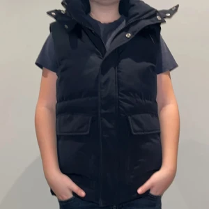 Icebound väst - Snygg svart dunväst från Icebound med dragkedja och knappar. Perfekt för kyligare dagar med sin quiltade design och praktiska fickor. Passar bra till både vardag och utflykter. Ny pris 2000kr~