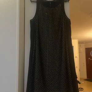Svart paljettklänning  - Snygg svart klänning med paljetter  som ger en festlig look. Klänningen är ärmlös och har en rak passform som passar perfekt för en utekväll. Den glittriga ytan ger en extra touch av glamour. En paljett saknas som det syns på bild. Priset går att diskutera! 