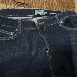 Mörkblå jeans från Dressmann - Snygga mörkblå jeans från Dressmann med klassisk femficksdesign och dragkedja. Perfekta för en stilren look. De har en rak passform och är tillverkade i slitstarkt denim.