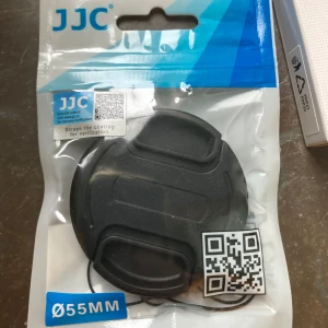 JJC objektivlock/linskydd 55mm - JJC objektivlock med en diameter på 55mm. Perfekt för att skydda ditt kameralins från damm och repor. Kommer med en praktisk rem för att undvika att tappa bort locket. Aldrig använd då den inte passade mitt objektiv.