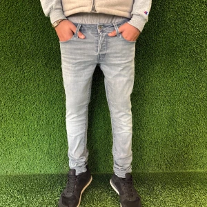 Slim jeans  - Snygga ljusblå jeansbyxor med en slim passform. De har en klassisk femficksdesign och är perfekta för en avslappnad stil. Byxorna har en dragkedja och knapp framtill.