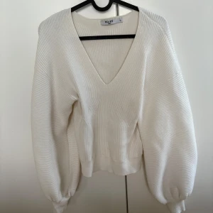 Vit ribbad tröja från NA-KD - Säljer en stilren vit ribbad tröja från NA-KD med v-ringning. Tröjan har långa ärmar och en bekväm passform, perfekt för kyligare dagar. Ett måste i garderoben för en enkel och snygg look.