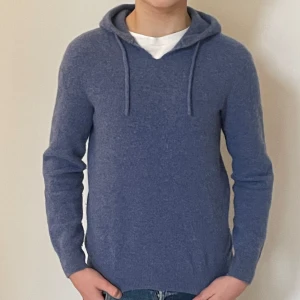 Blå cashmere Hoddie i storlek Xs (liten i passformen) - Säljer en mjuk och stilren blå hoodie i kashmir. Tröjan har långa ärmar och en klassisk huva med med snören. Perfekt för kyliga dagar och ger en lyxig känsla. Passar både till jeans och mer avslappnade outfits. Passar dig som är ca 155-165cm Prisförslag kan diskuteras vid snabbt köp!!