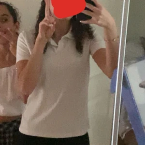 Vit ribbad polotopp - Säljer en stilren vit ribbad polotopp i mycket bra skick. Den har korta ärmar och en klassisk krage, perfekt för både vardag och lite mer uppklädda tillfällen. Passar bra till jeans eller kjol för en avslappnad men ändå snygg look. Den är egentligen i storlek 164 men passar perfekt som XS