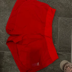 Rosa träningsshorts - Snygga rosa träningsshorts med texten 'RUN IT' på framsidan. Perfekta för löpning eller gymmet. De har en bekväm passform och en praktisk dragkedja på sidan.