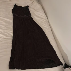 Lång klänning  - Lång svart klänning med med brons glitter! Använt endast en gång, nypris 800kr. Pris kan diskuteras!!