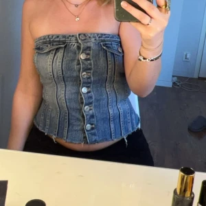 Jeans tubtopp med knappar - Säljer en snygg jeans tubtopp med knappar framtill.