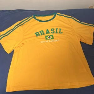 Brasilien T-Shirt - Köptes i Brasilien Sommaren 2024,Använd en gång under en fotbollsmatch annars inte använd alls,den är väldigt stor i storlek och är väldigt stor på mig,Jätteskönt och uttöjbart matrial,Allmänt en fin och skön tröja men används inte.