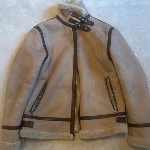 Zara vinterjacka L - Snygg beige jacka från Zara med mörka detaljer och dragkedjor. Jackan har använts en vinter och sedan hängt och väntar på ny användare. Storlek: Large(L). Pris 300kr. Stockholm eller fraktas