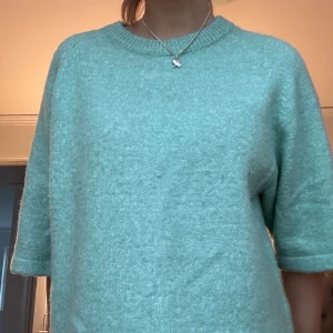 Mintgrön stickad trekvarts tröja - Säljer en mysig mintgrön stickad tröja med trekvartsärm. Perfekt för en avslappnad stil och passar bra till både jeans och kjol. Tröjan har en rund halsringning och är i en mjuk och bekväm kvalitet.