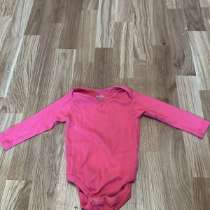 Rosa långärmad body från Lupilu - Säljer en söt rosa långärmad body från Lupilu. Perfekt för de små under vår och höst. Tillverkad i mjukt material för extra komfort. Passar barn i storlek 74/80.