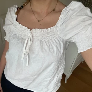 Vit blus  - Säljer en söt vit blus med puffiga kortärmar och smockdetaljer, från H&M i storlek XS🤍 (Toppen på bilden är inte struken) 